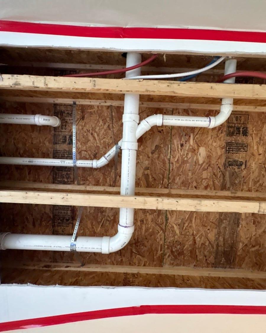 Framing and plumbing exposed where damaged drywall was cut out