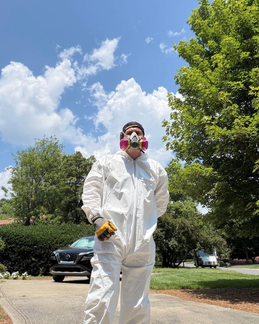 A Phantom Restoration technician in a protective suit and respirator on a job site