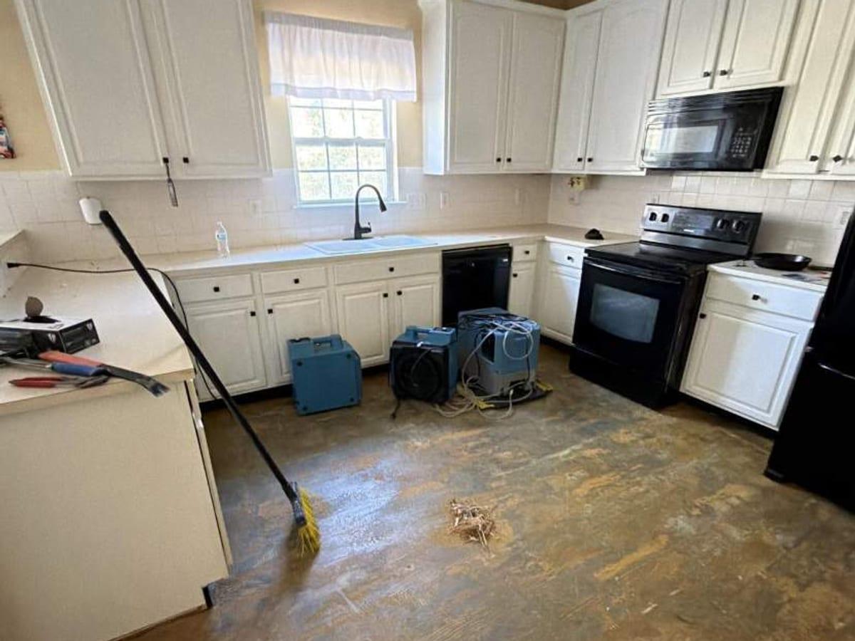 Drying equipment in a kitchen with the damaged flooring removed