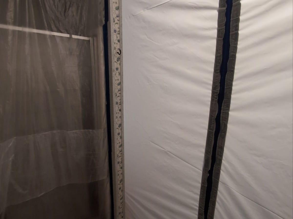 Plastic containment with a zippered entry set up for mold remediation