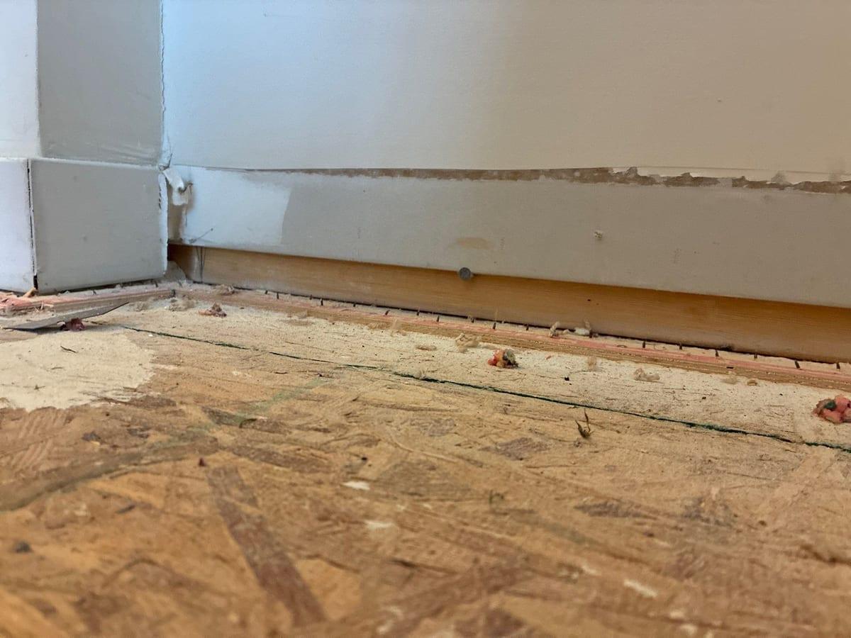 Drywall cut away along the base of a wall after water damage