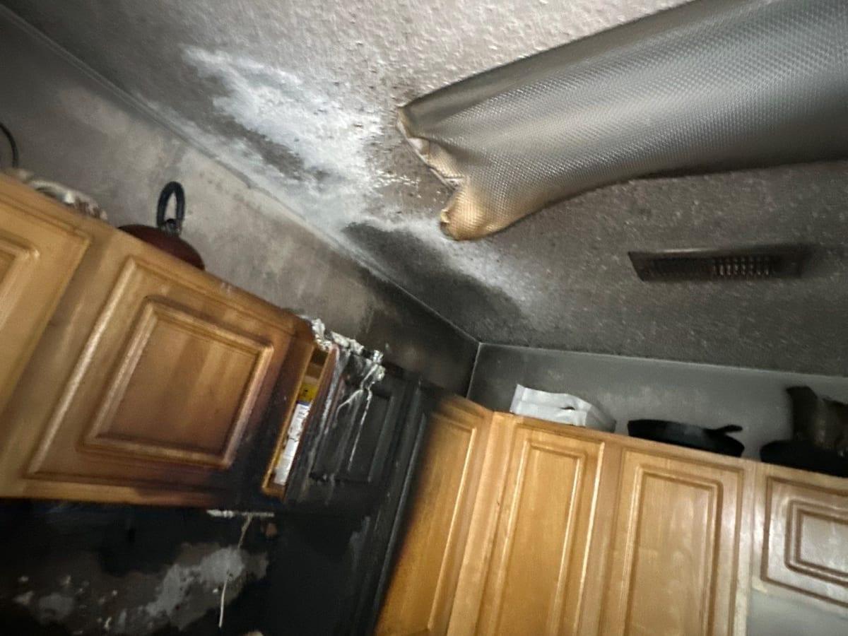 Soot on a kitchen ceiling and cabinets before cleanup