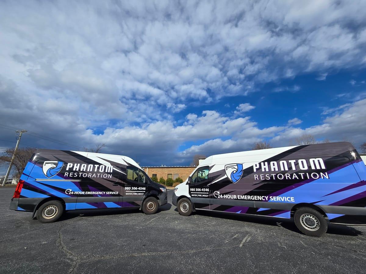 Two Phantom Restoration vans parked nose to nose