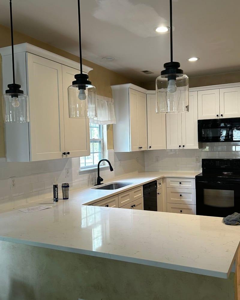 The same kitchen finished with white cabinets and a new floor