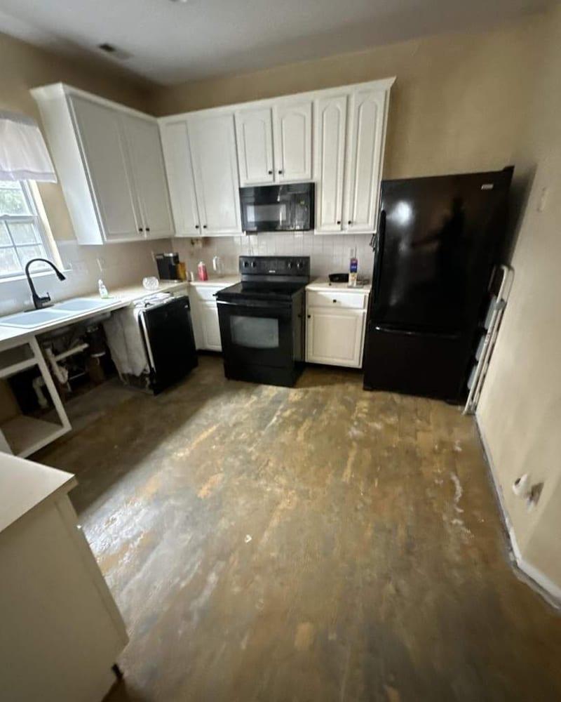 A kitchen with the floor taken up during drying