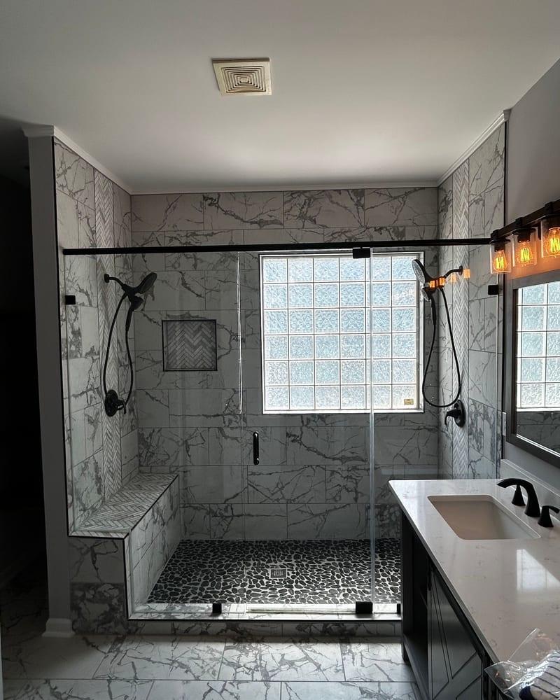 The rebuilt bathroom with a tiled walk-in shower and glass door