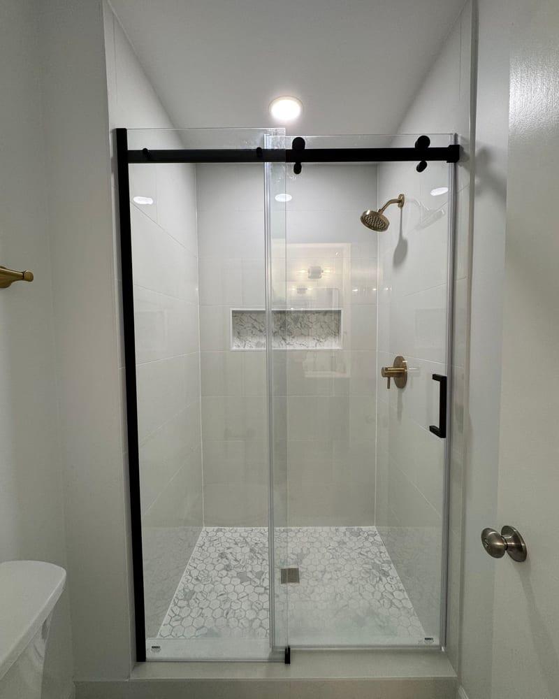 The rebuilt bathroom with a glass shower and new tile