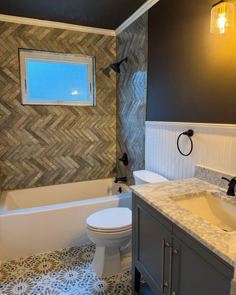 The rebuilt bathroom with a new tub surround, vanity and tile